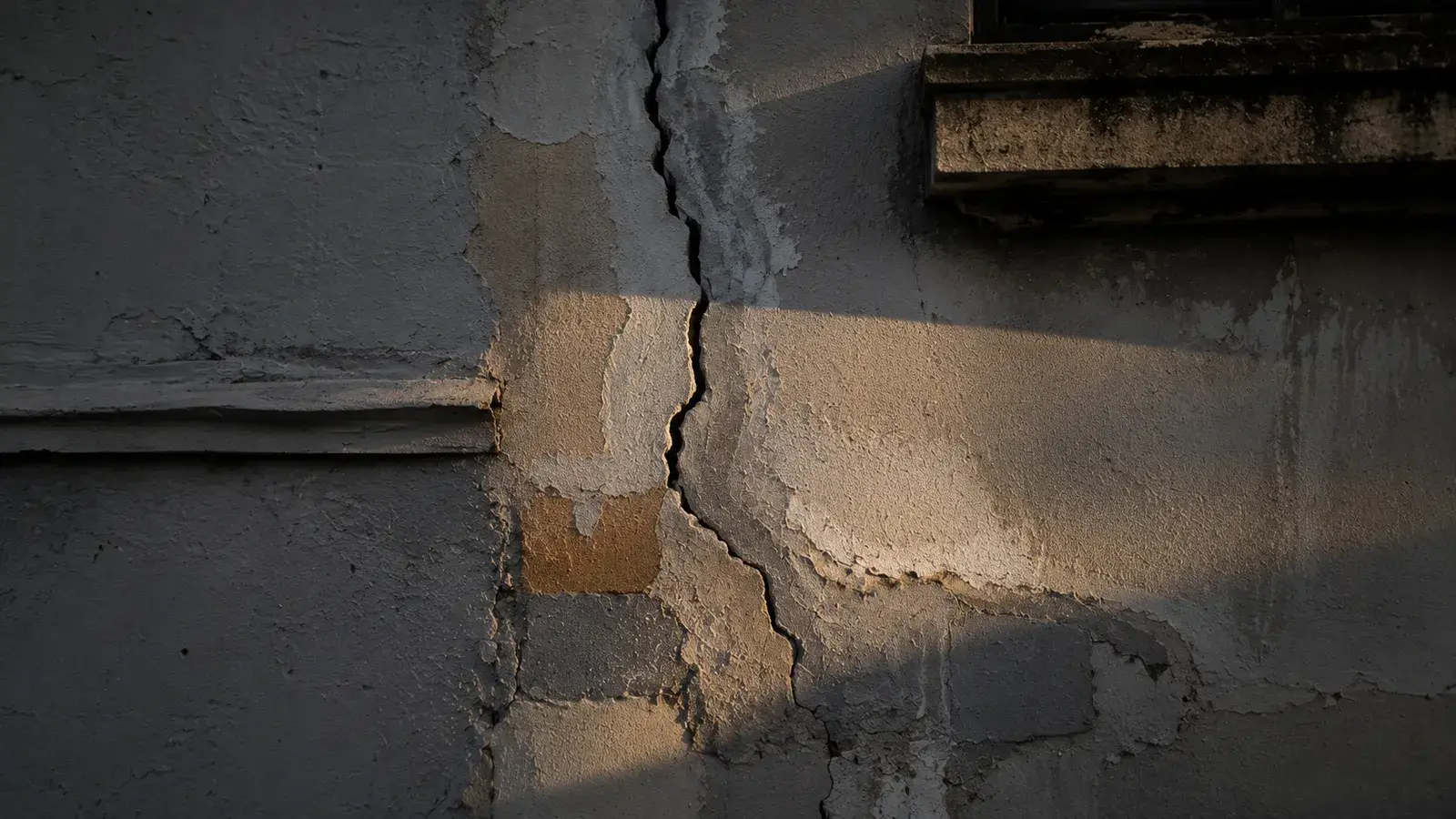 Insurance adjuster marking a chalk test square while documenting storm damage on a residential roof